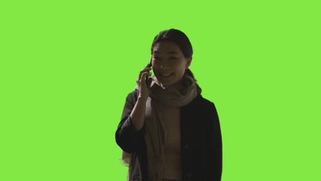 Low-Key-Studio-Shot-Of-Woman-Answering-Call-On-Mobile-Phone-Against-Green-Screen-1